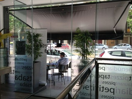 Puerta automática de cristal de apertura doble, de gran altura (3 metros), el automatismo esta escondido en el falso techo.